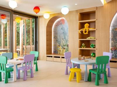 Kinderspielzimmer mit bunten Stühlen und Tischen in einem Hotel.