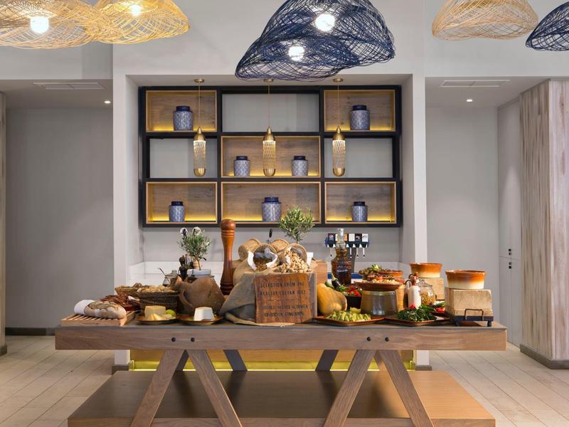 Een buffet met gebak en decoraties voor een wandplank in een elegante hotelkamer.