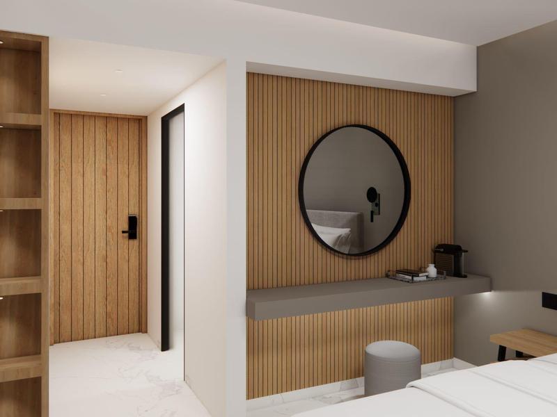 Modern hotelkamer met eenvoudig houtdesign, ronde spiegel en warme verlichtingsarmaturen.