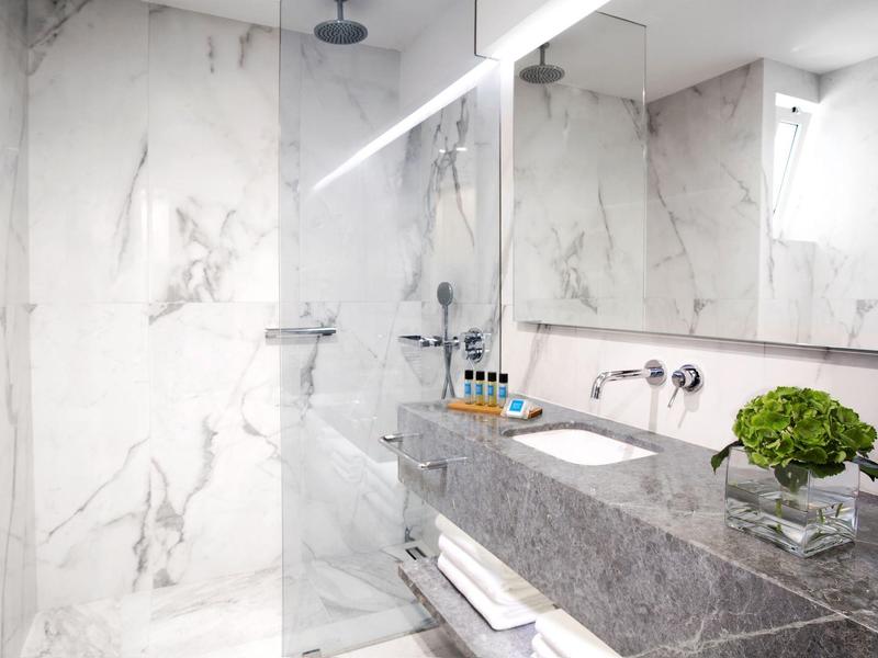 Moderne badkamer met marmeren muren en grijs stenen aanrecht in hotel