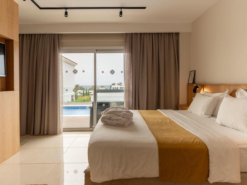 Modern hotelkamer met groot bed en uitzicht op het zwembad door een glazen schuifdeur.