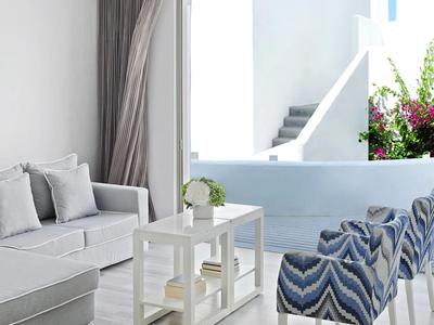 Cozy terrace with seating area, tables, and flowers under natural light.