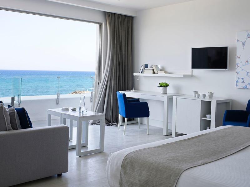 Elegantes Restaurant mit runden Tischen, bequemen Stühlen und großen Fenstern, blauer Abendhimmel.