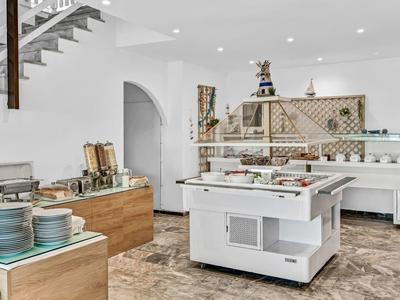 Modern eingerichtete Selbstbedienungs-Küche mit weißen Möbeln und Holzdetails.