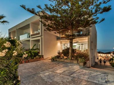 Hotel moderno con area esterna e piante al crepuscolo.