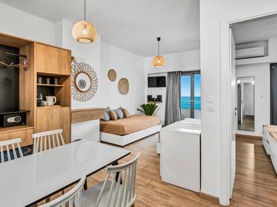 Moderner Wohnbereich mit Essplatz, Sofa, Dekoration und Meerblick durch große Fenster.