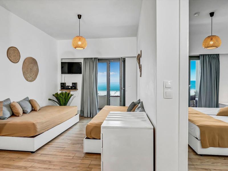 Moderne Hotelzimmer mit Bett, Pflanzen und Blick auf das Meer durch Fenster