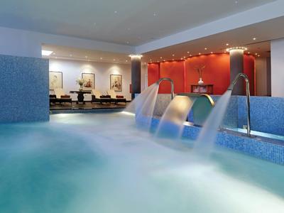 Innenbereich eines Wellnesspools mit drei Wasserstrahlen und entspannter Atmosphäre.