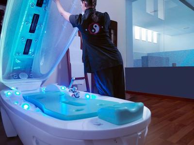 Urządzenie kapsuły wellness z niebieskim światłem w nowoczesnym spa z drewnianą podłogą.