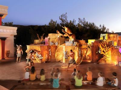 Abendvorführung mit Schauspielern in farbenfrohen Kostümen vor antiker Kulisse im Freien