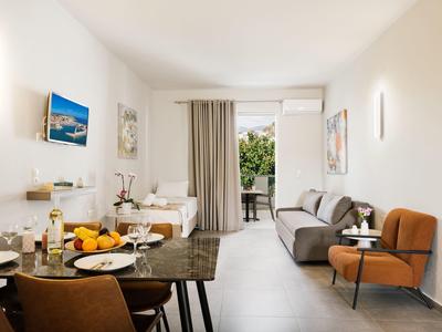 Soggiorno luminoso con tavolo da pranzo, divano e accesso al balcone con vista sul verde.