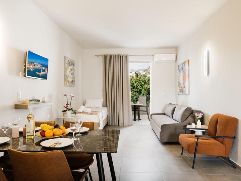 Soggiorno luminoso con tavolo da pranzo, divano e accesso al balcone con vista sul verde.