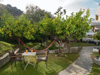 Příjemné venkovní posezení se stolem, židlemi a houpací sítí vedle zahradní cesty