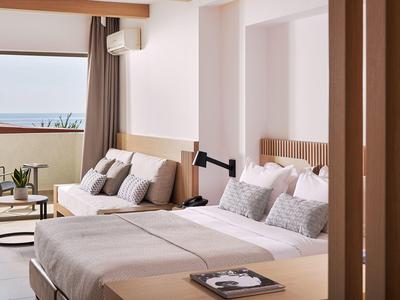 Chambre d'hôtel moderne avec lit double et balcon avec vue sur la mer.