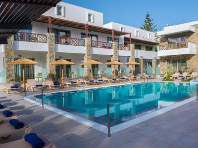 Moderner Hotelpool mit blauer Wasserfläche, Liegestühlen und Sonnenschirmen vor weißem Gebäude.