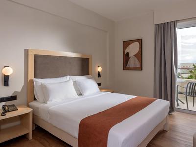 Nowoczesny pokój hotelowy z łóżkiem podwójnym i balkonem z widokiem.