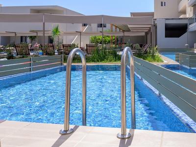 Nowoczesny basen na zewnątrz z metalową barierką w hotelu z tarasem słonecznym w tle.