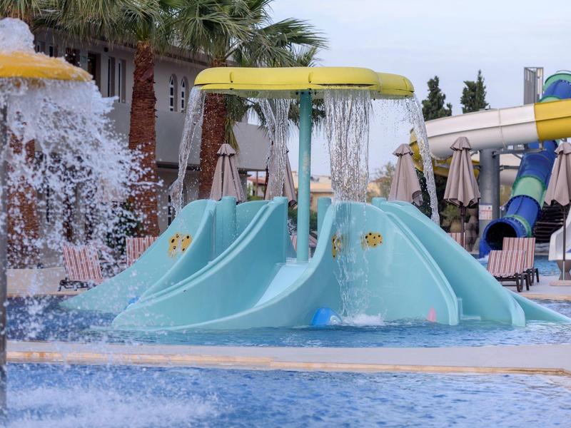 Kolorowy plac zabaw wodny ze zjeżdżalniami i fontannami w basenie hotelowym