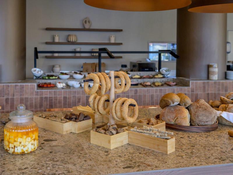 Bufet z różnymi rodzajami pieczywa i wypieków na kamiennym blacie w nowoczesnej restauracji