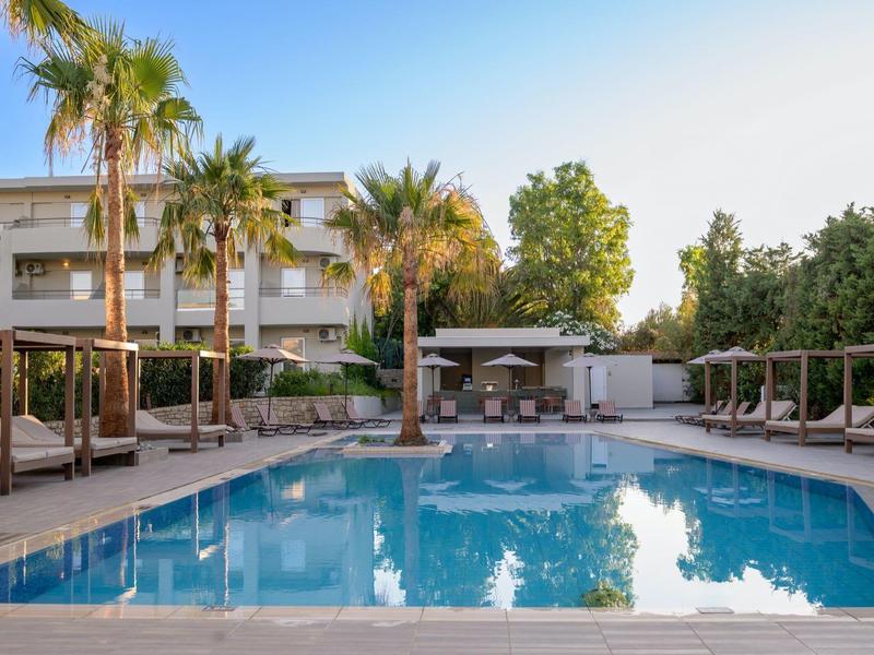 Nowoczesny basen hotelowy z leżakami, parasolami i palmami pod czystym niebem.