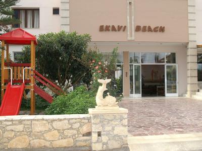 Eingang eines Hotels mit rotem Spielturm und Sandsteinmauer im Vordergrund.