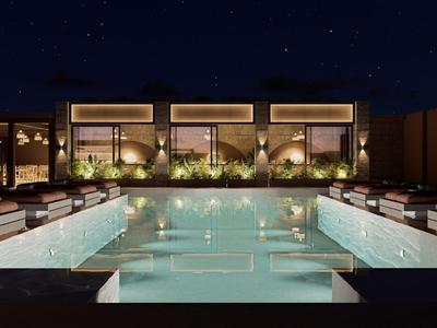 Luxuriöser Hotelpool bei Nacht mit bequemen Liegen und stilvoller Beleuchtung.