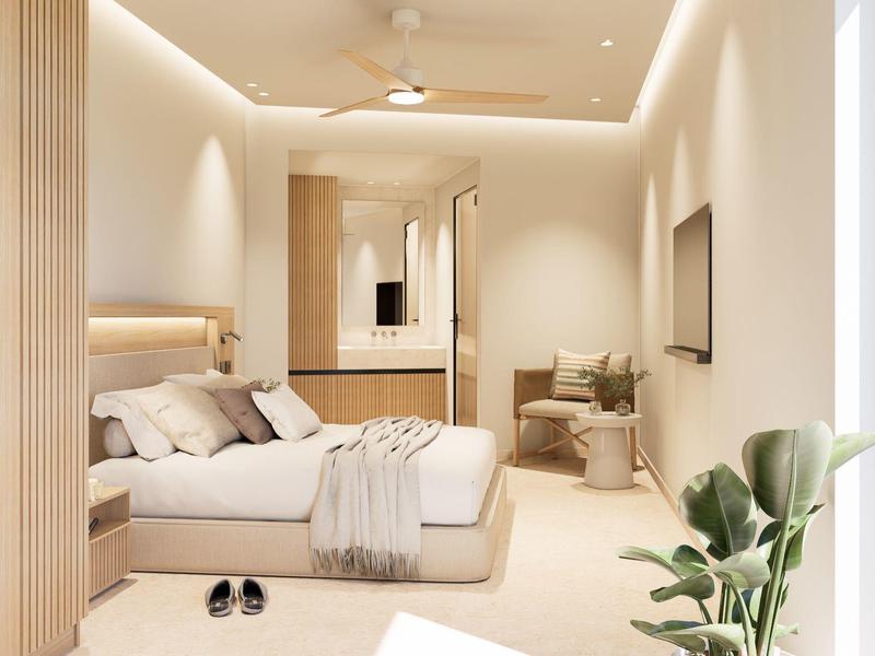 Modernes Hotelzimmer mit Doppelbett, Sessel, Pflanzen und indirekter Beleuchtung.