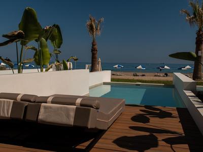 Piscine moderne avec chaises longues et vue sur la mer de nuit