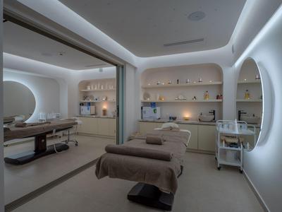Salle de spa moderne avec deux tables de massage et éclairage LED doux aux murs.
