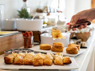 Verse gebakjes met honing worden geserveerd op een buffet in een lichte ruimte.