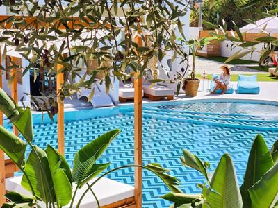 Piscina dell'hotel con acqua turchese e piante verdi in primo piano