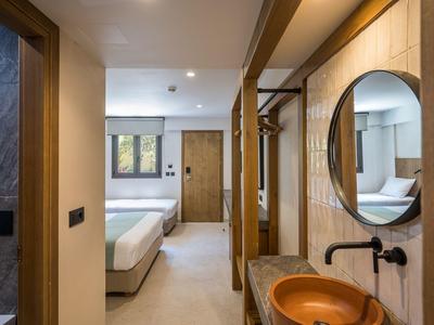 Moderner Flur mit hellem Boden, Holztür, Rundspiegel und orangefarbenem Waschbecken.