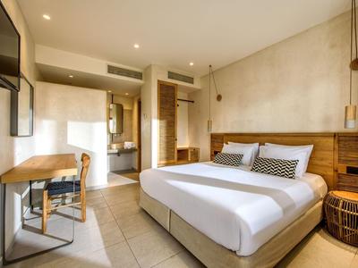 Chambre d'hôtel moderne avec lit double, bureau et intérieur lumineux et élégant.