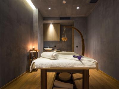 Salle de massage moderne et simple avec parquet, éclairage tamisé et mobilier élégant.