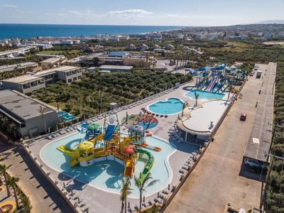 Vue aérienne d'un parc aquatique avec toboggans et piscines près de la côte.