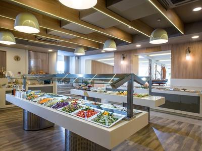 Grand buffet de restaurant d'hôtel avec décoration en bois chaud et diverses options alimentaires.