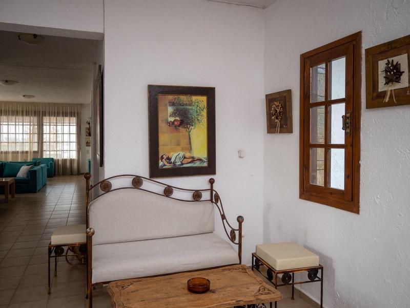 Pohodlný posezení s pohovkou, dřevěným stolem a okny v světlé místnosti.