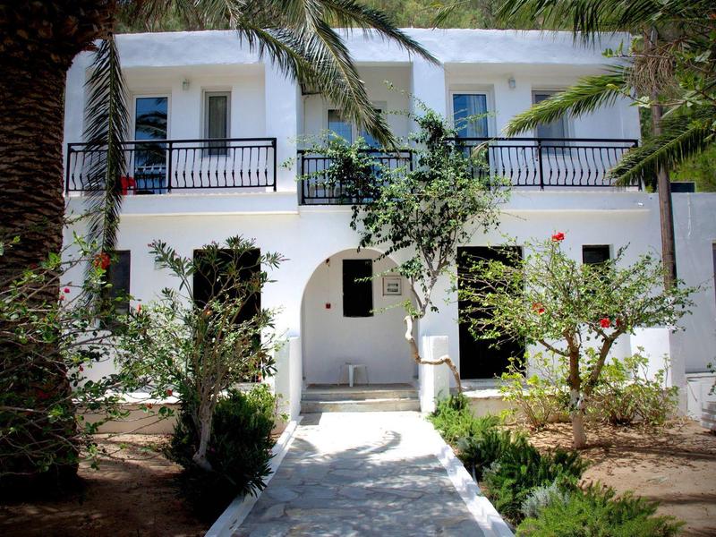 Edificio dell'hotel bianco con balconi e vegetazione tropicale circostante.