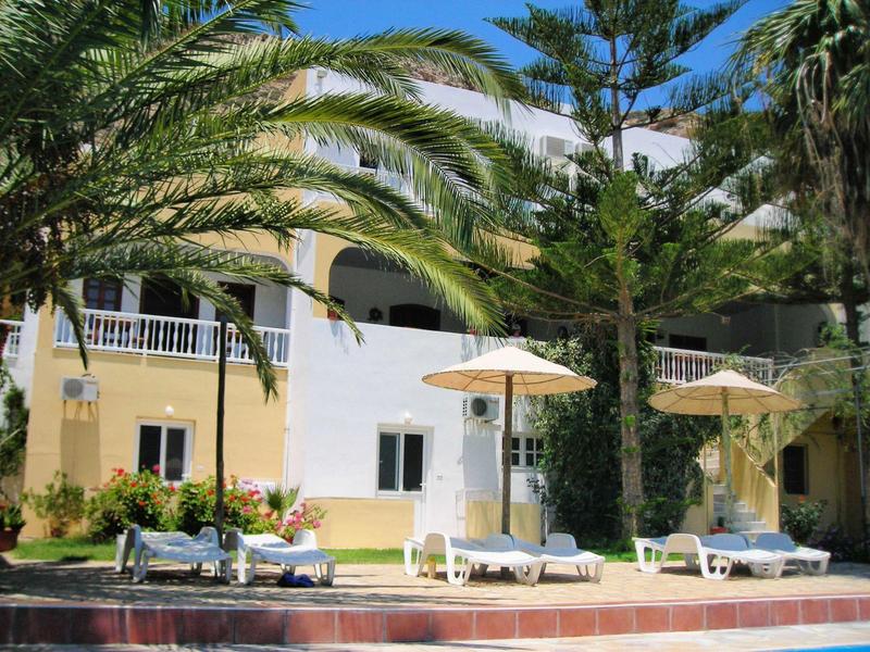 Hotelterras met ligstoelen en parasols omgeven door palmbomen en tuin