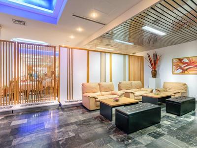 Nowoczesna część wypoczynkowa hotelu z wygodnymi sofami i stylowym oświetleniem.