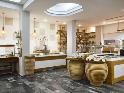 Jasne, nowoczesne śniadaniowe bufet z ceramicznymi naczyniami i żyrandolami w hotelowym otoczeniu.