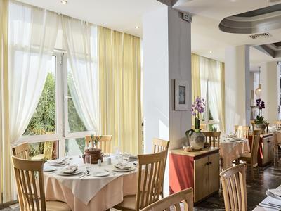 Bright restaurant with set tables and large windows letting in daylight.