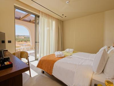 Helles Hotelzimmer mit Doppelbett, Balkon und Bergblick.