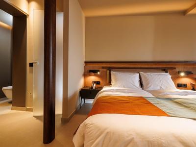 Modern eingerichtetes Hotelzimmer mit Doppelbett, warmem Licht und sauberem Ambiente.