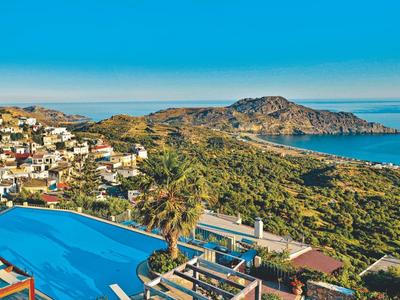 Hotel con grande piscina e vista mare su una costa collinare sotto cielo limpido