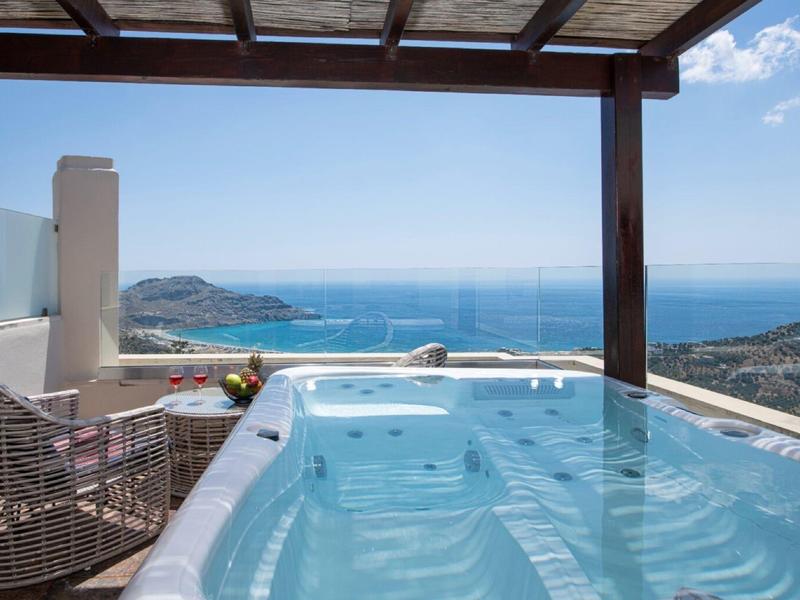 Vasca idromassaggio su balcone con vista sul mare e cielo parzialmente nuvoloso