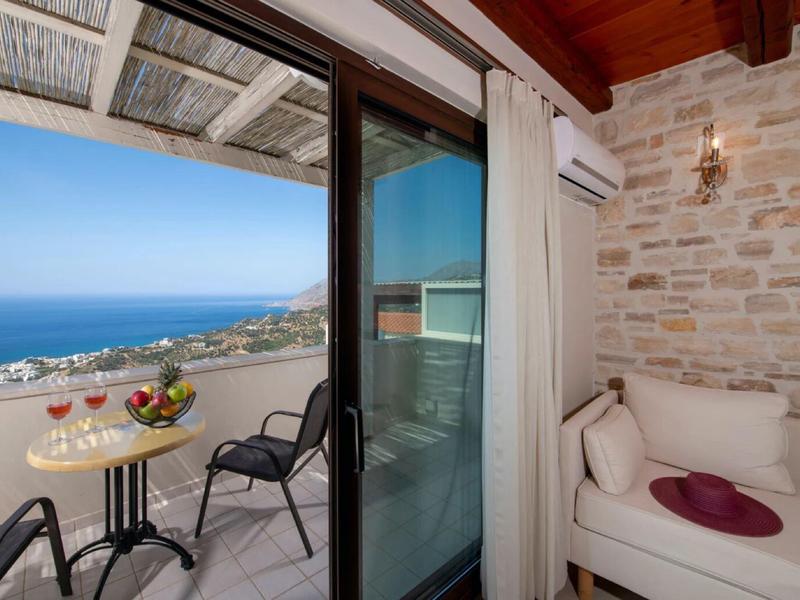 Balcone con posti a sedere e vista mare, adiacente a un interno accogliente con divano.