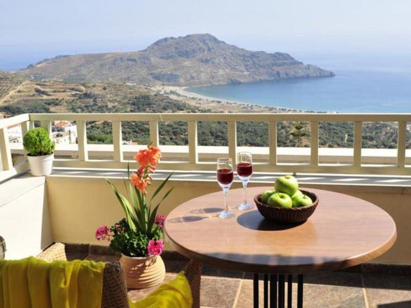 Balcone con tavolo, sedia, fiori e vista sul mare e montagne con sole