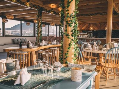 Accogliente zona ristorante con mobili in legno e vista sulle montagne alla luce del giorno.