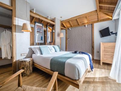 Chambre d'hôtel cosy avec meubles en bois, lit double et décor moderne.